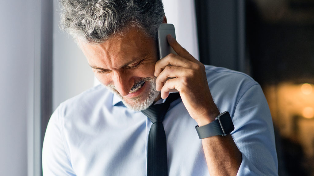 man with hearing aids on the phone